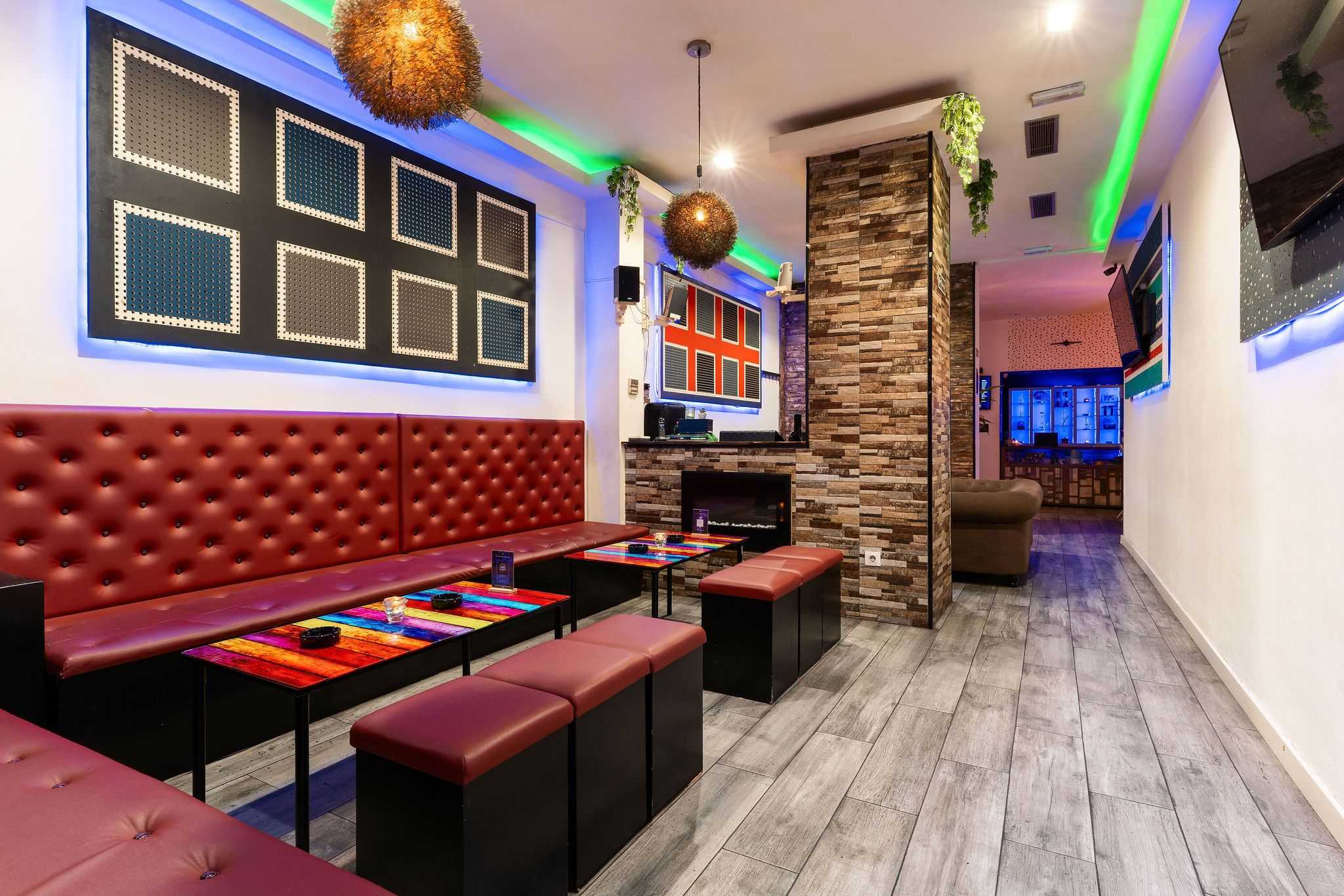 Colorful lounge with benches and wall art in the Smoke Signals social club Barcelona